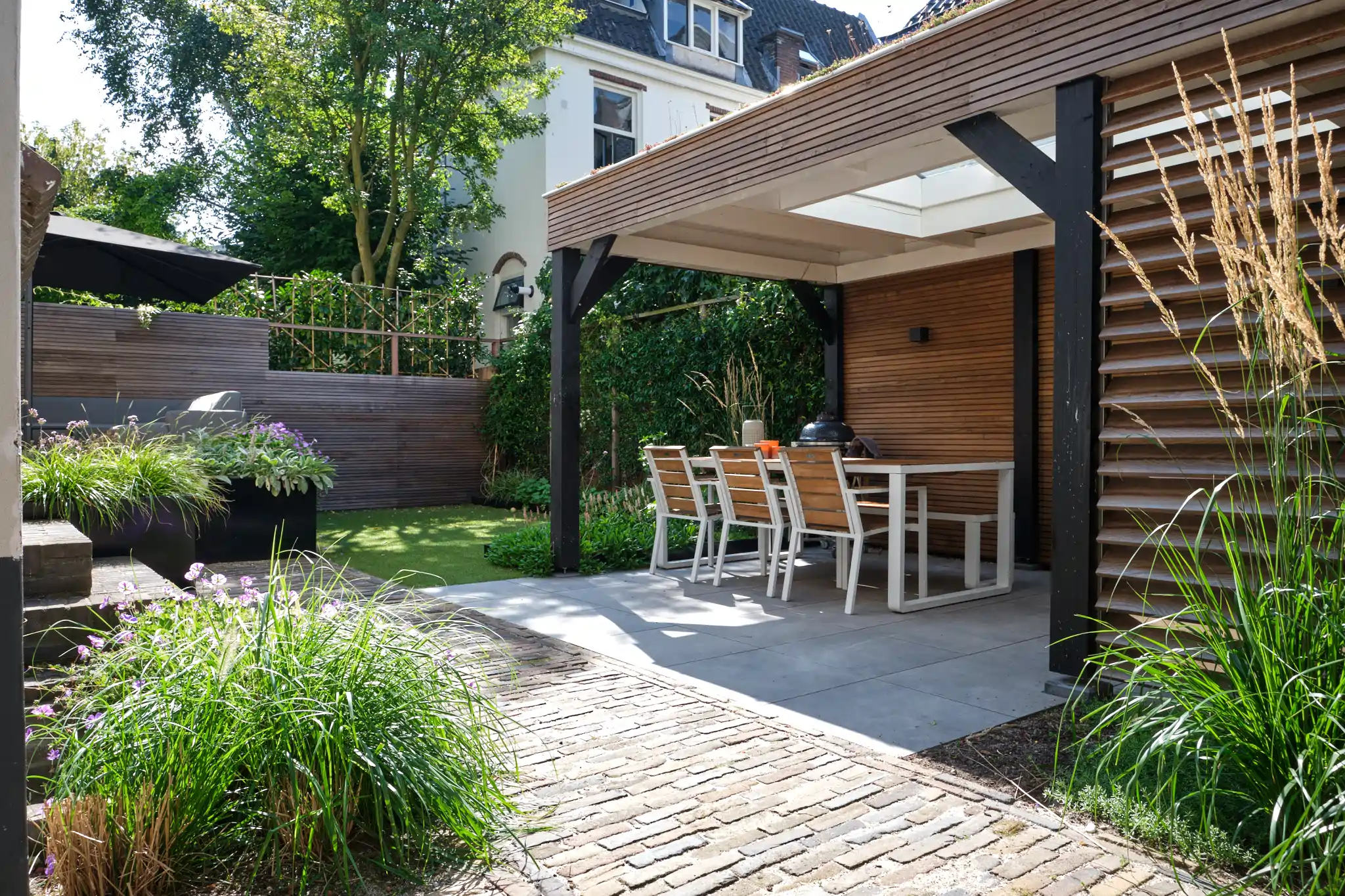 Compleet tuinzicht met paviljoen, eethoek en landschapsarchitectuur