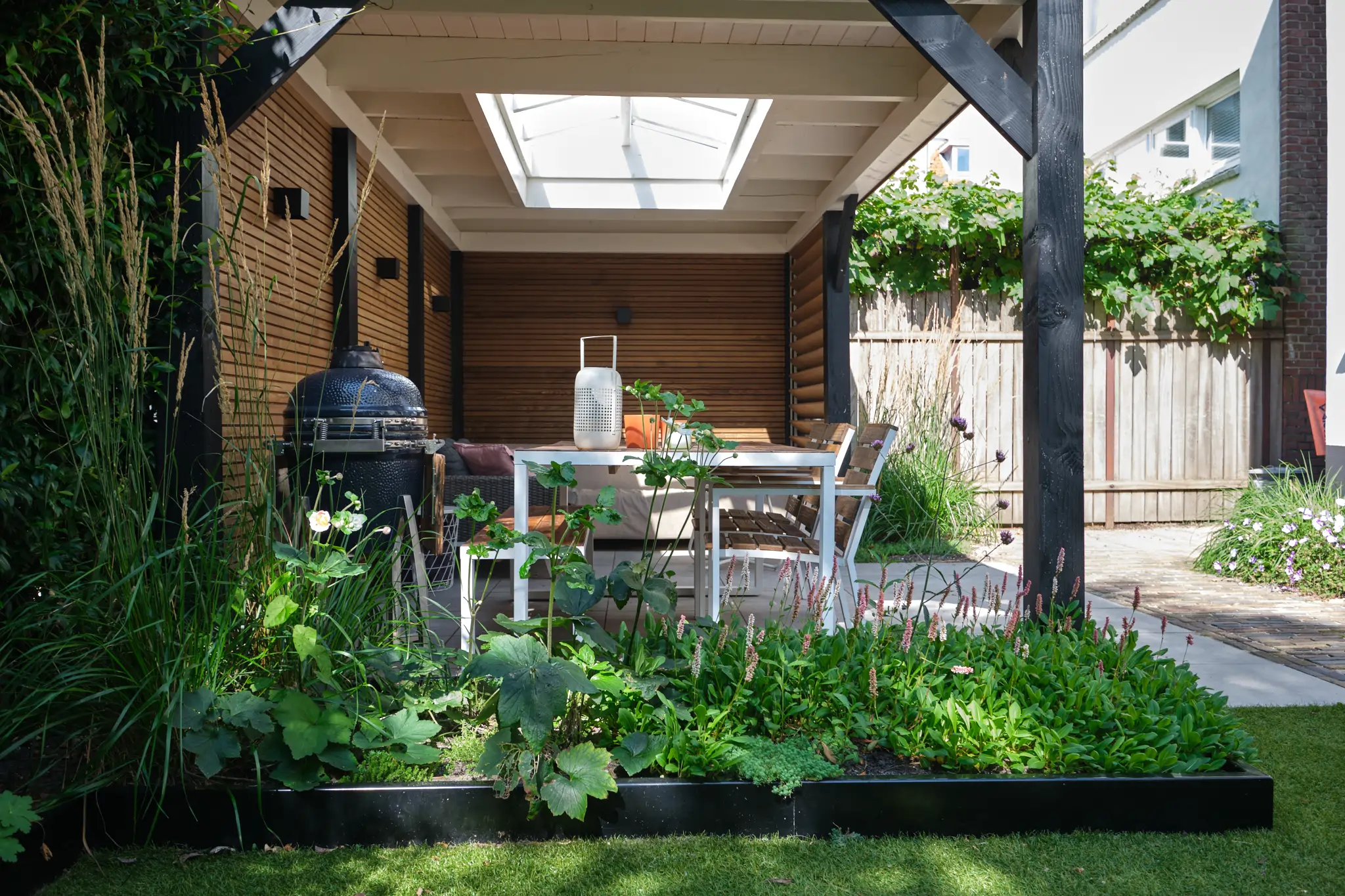 Overdekte eethoek met daklicht, barbecue en moestuinbakken