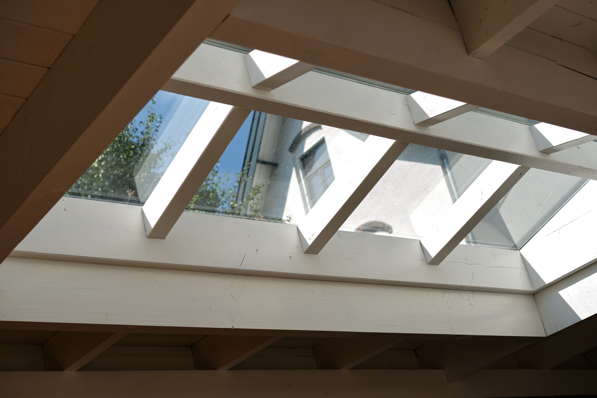 Interieur zicht naar boven met houten balken en glazen dakramen