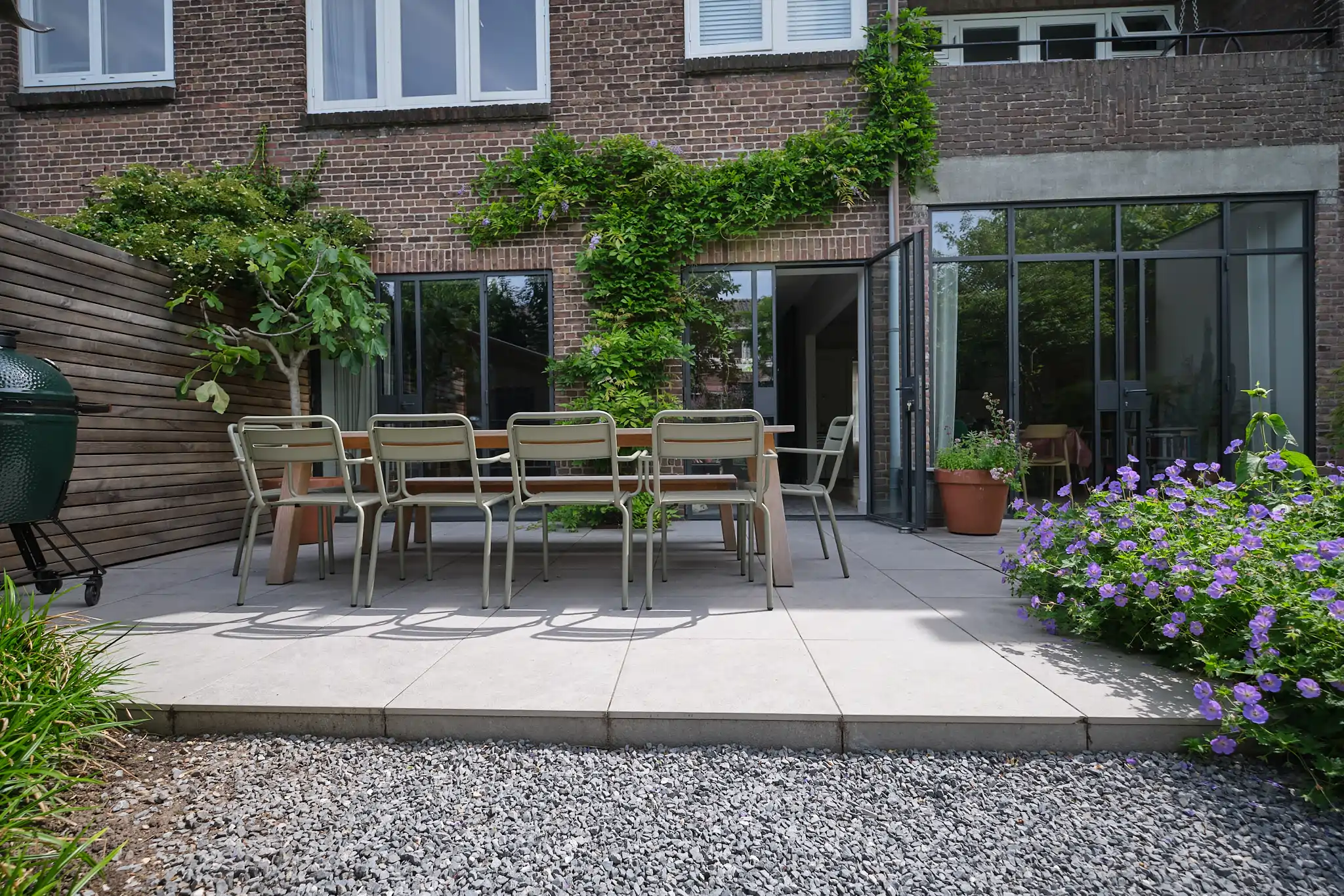Modern eetterras met eigentijdse stoelen en houten tafel