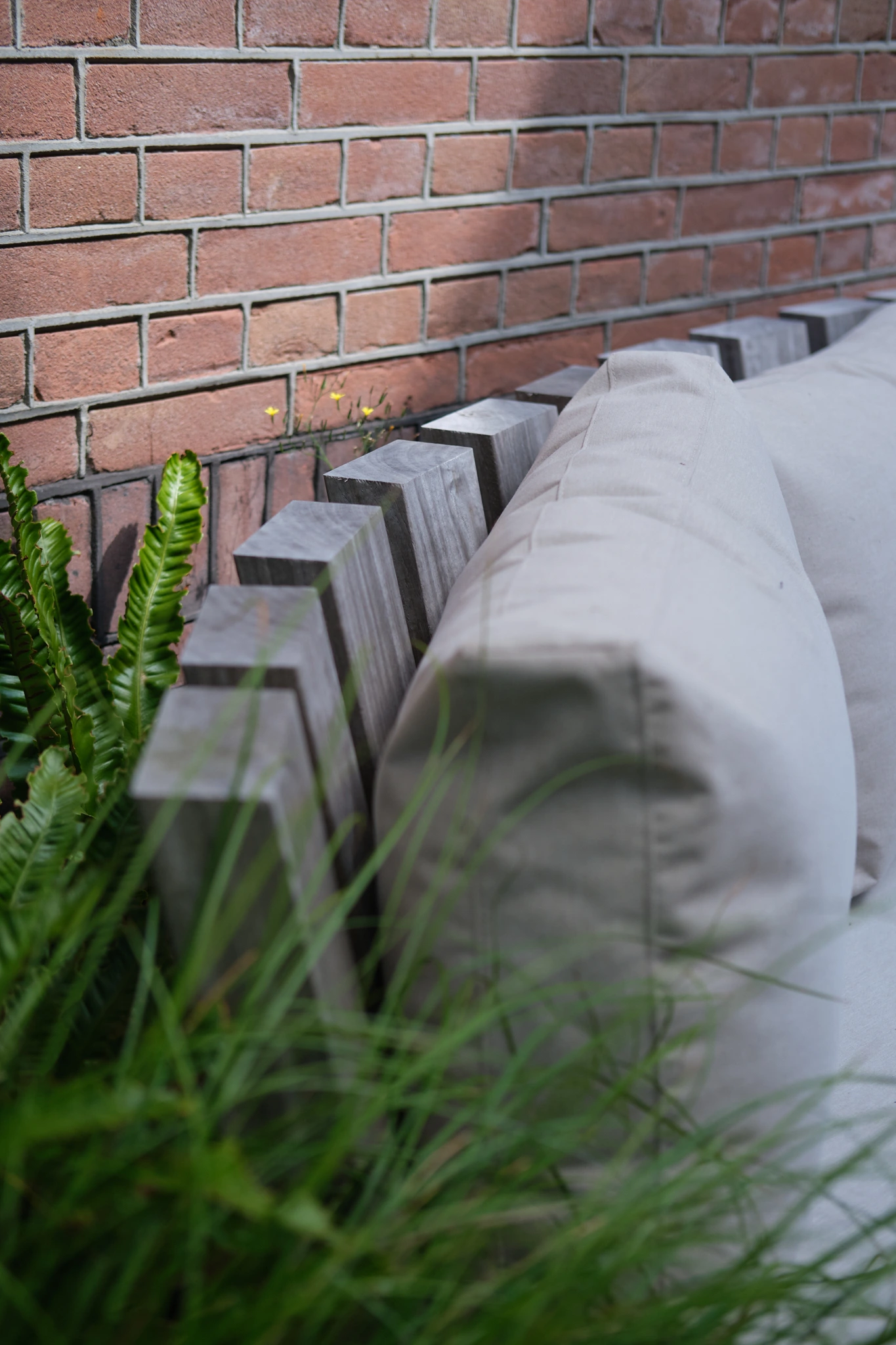 Detail van betonnen elementen tegen bakstenen muur met groene beplanting