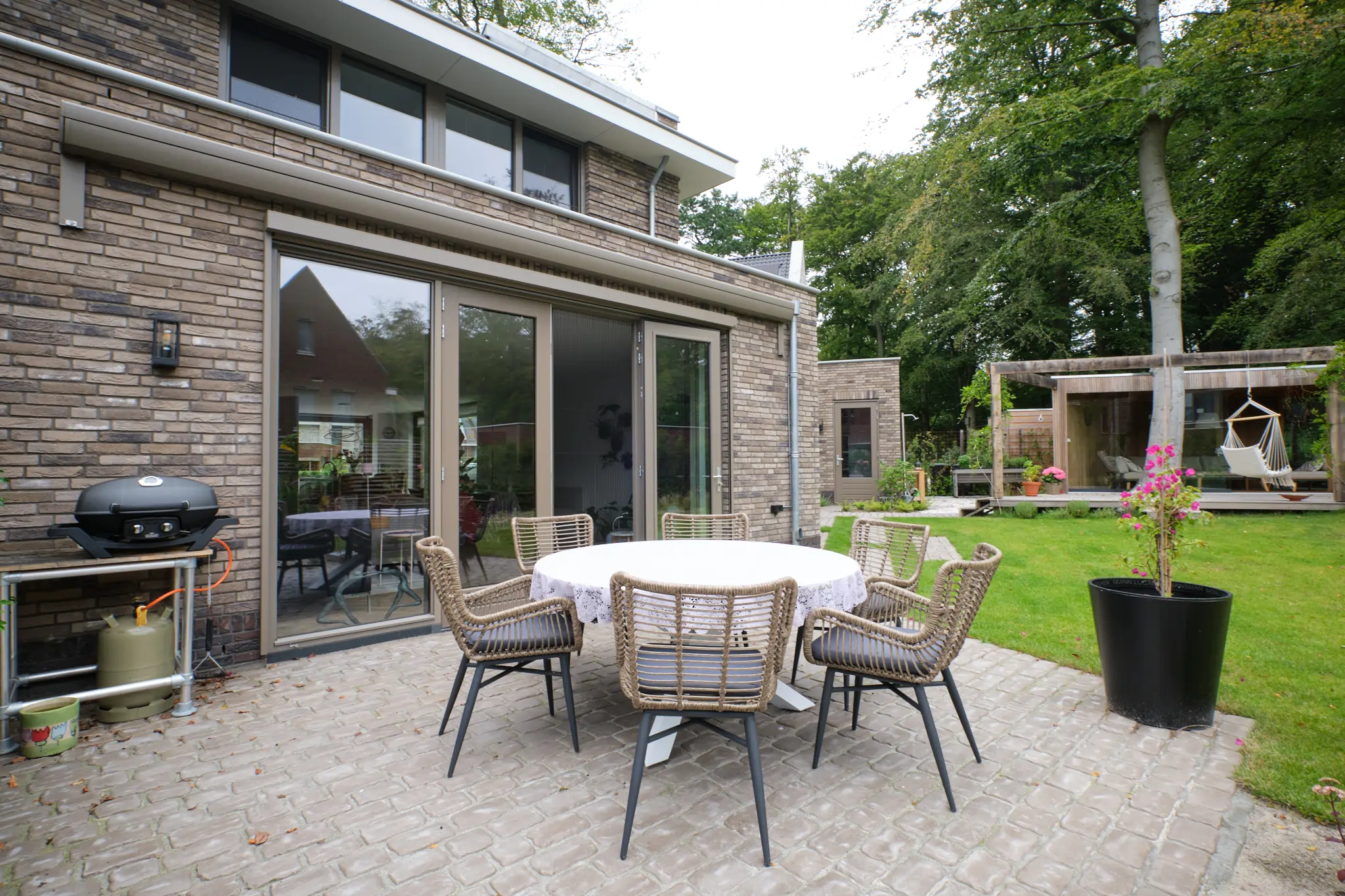 Eetterras met moderne tuinmeubelen en BBQ