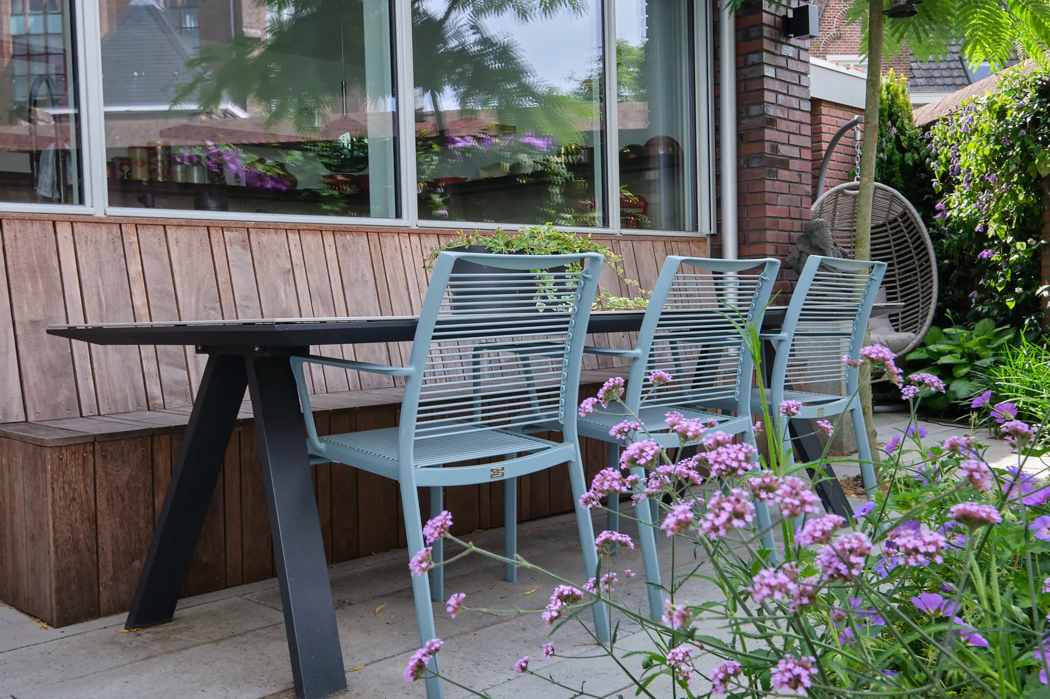 Moderne eethoek met lichtblauwe stoelen en roze Verbena bonariensis