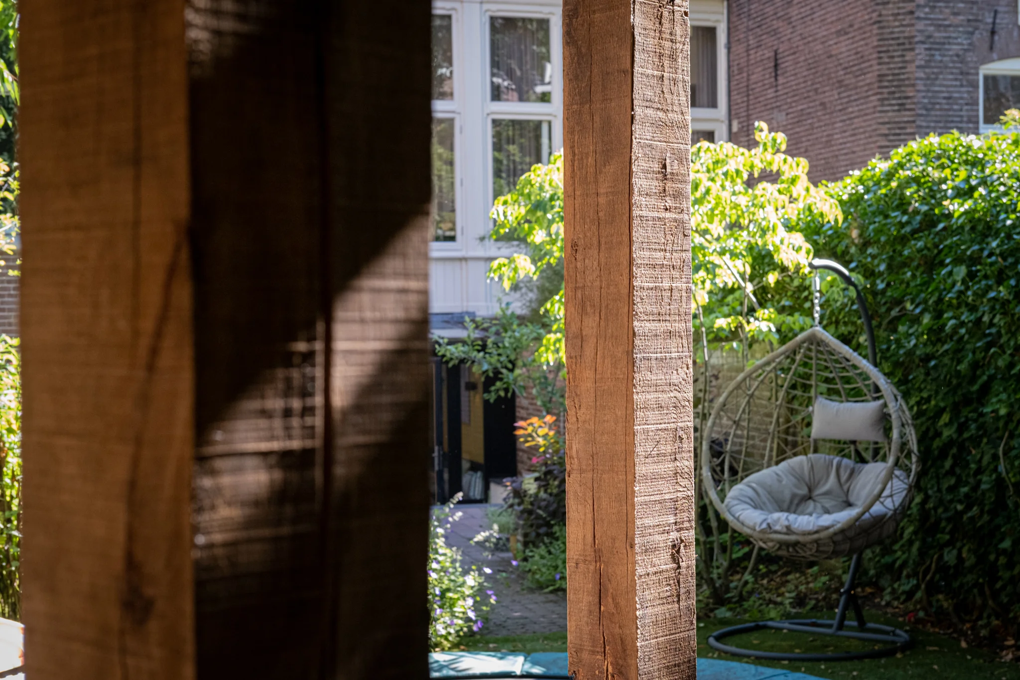 Hangstoel en uitzicht vanuit de shelter naar de tuin