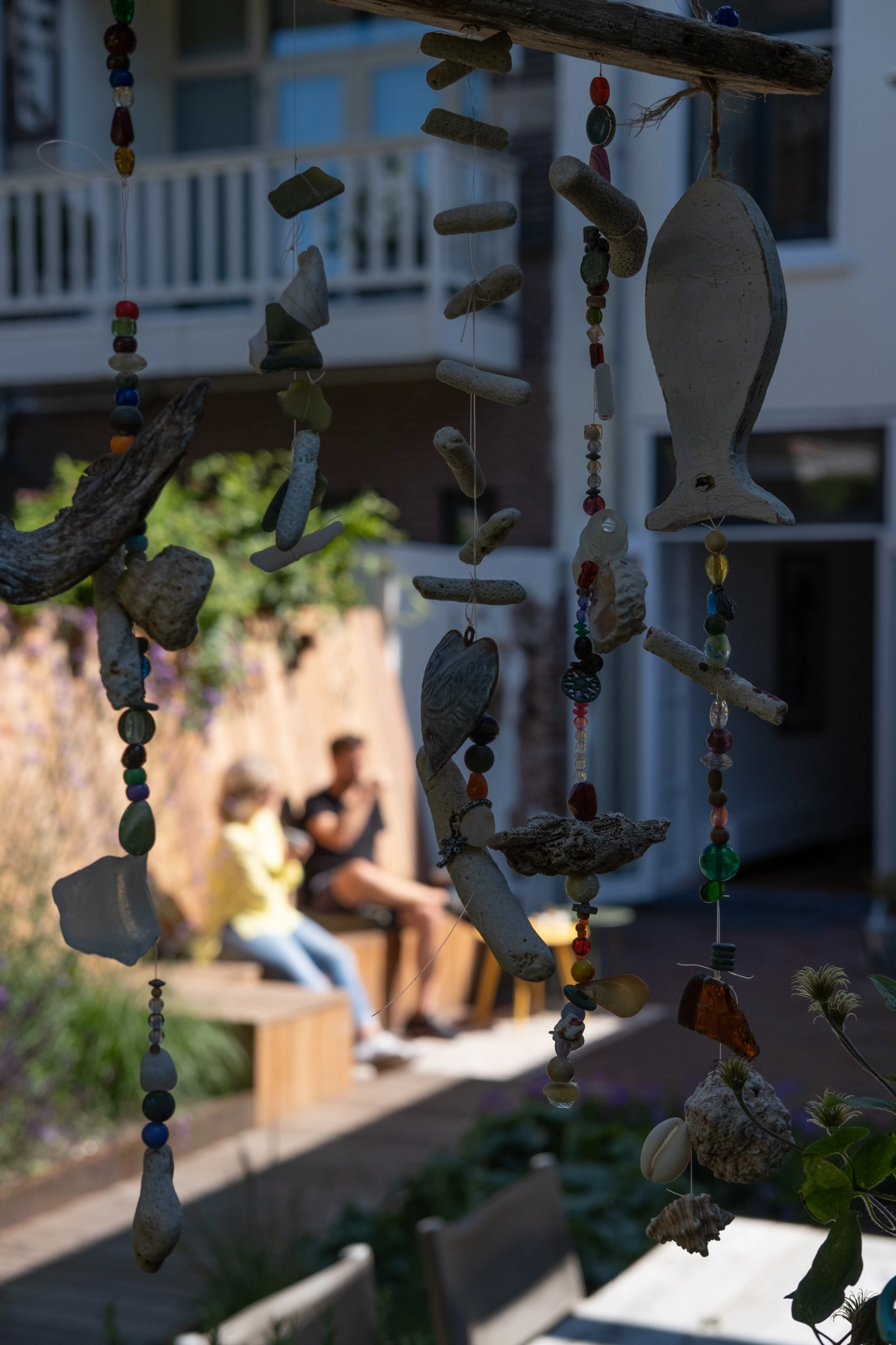 Artistieke hangende decoraties van drijfhout en kralen in de tuin