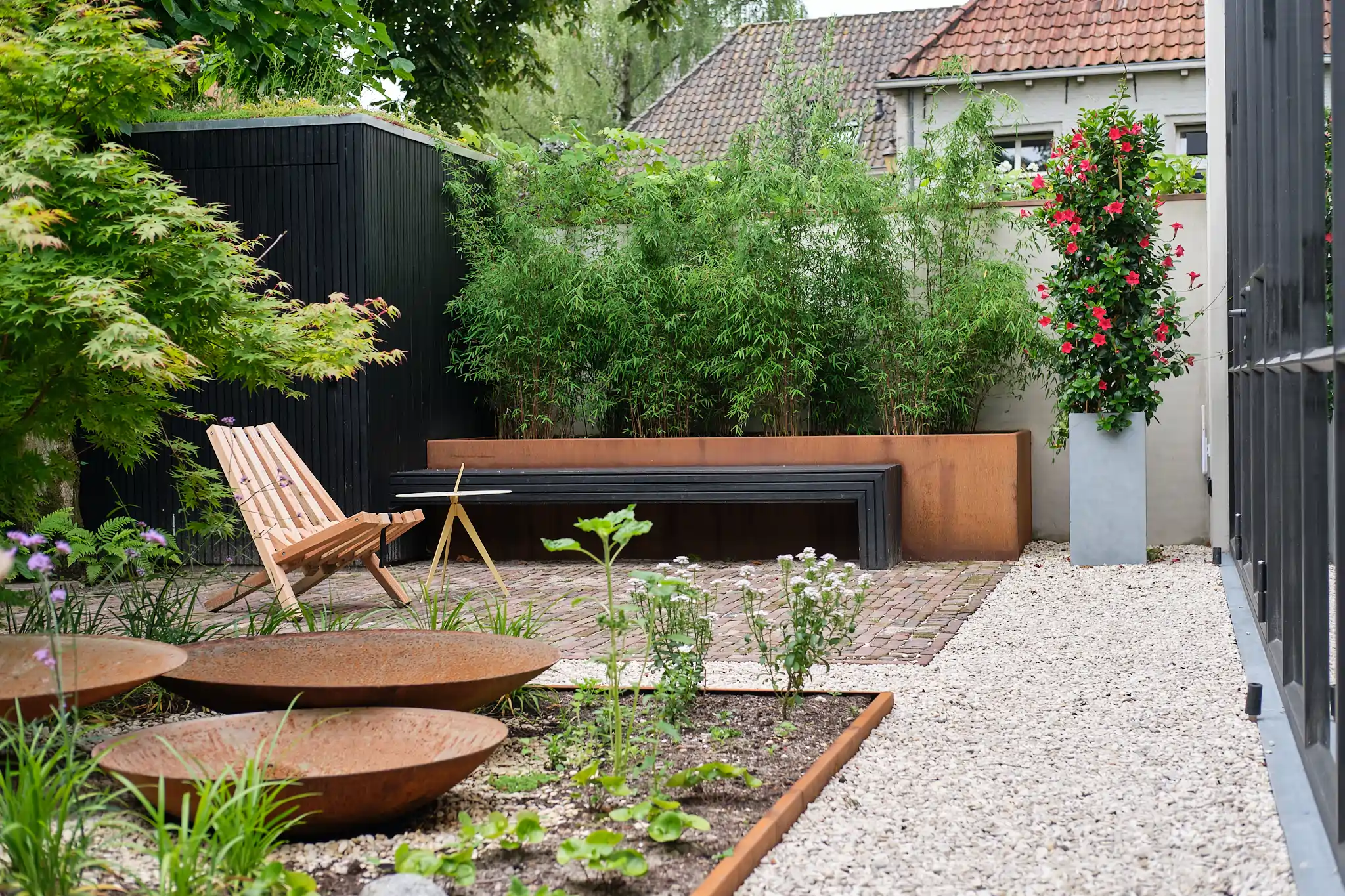 Tuinhoek met corten staal planters en bamboe screening