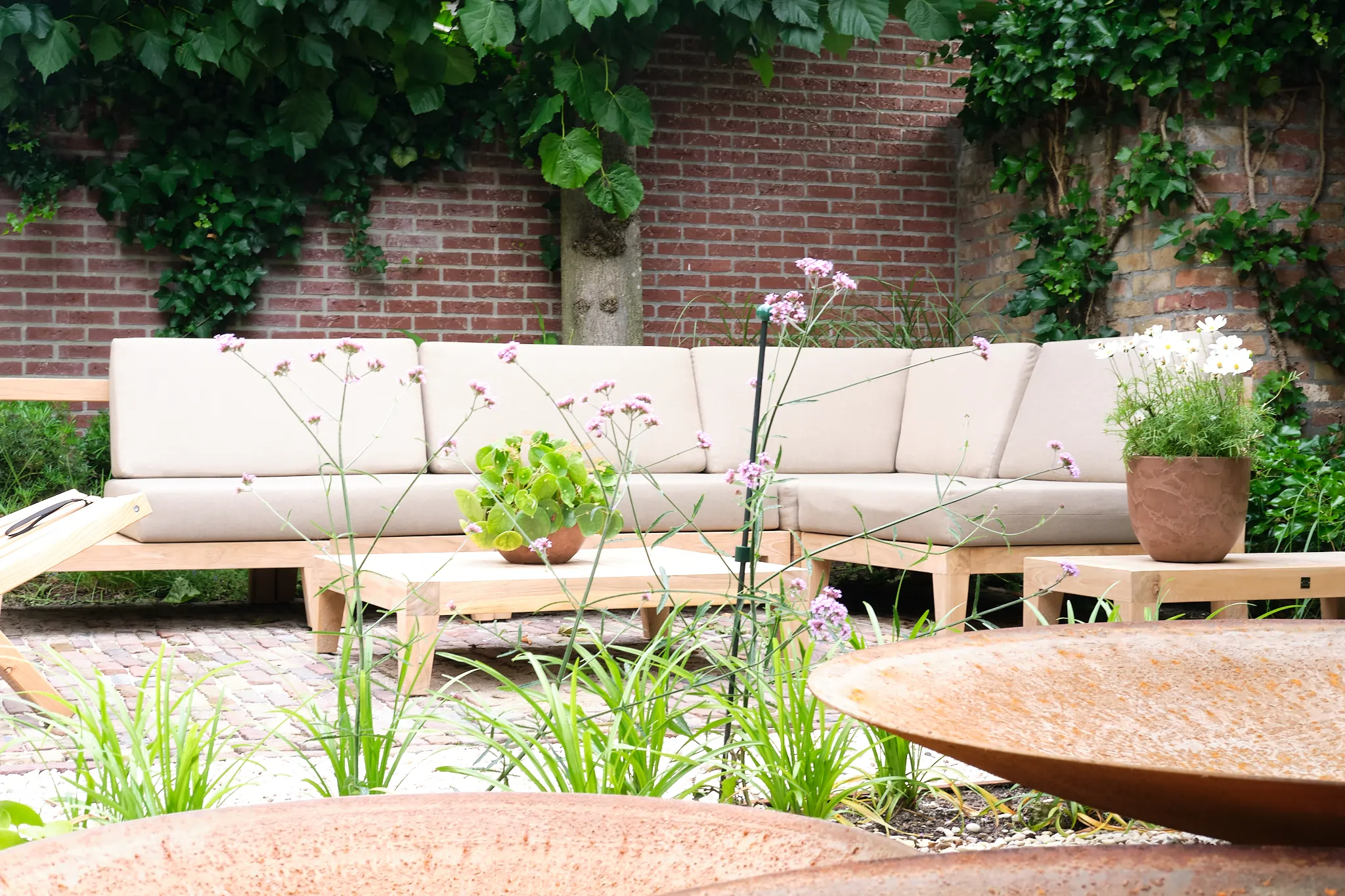 Moderne zithoek met beige kussens tegen bakstenen muur